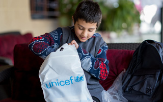 En gutt mottar skolemateriell fra UNICEF, Libanon