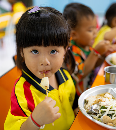 Et barn spiser lunsj i barnehagen, Thailand