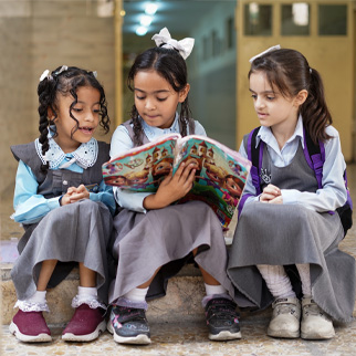 Tre jenter sitter sammen og leser, Irak