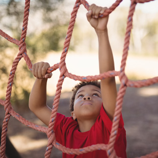 En gutt klatrer i et lekestativ