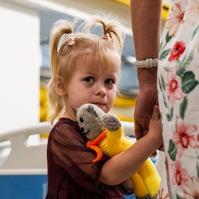 I et fluktrom på et sykehus holder en nente fra Ukraina mammaen sin i hånden. 2025. FOTO