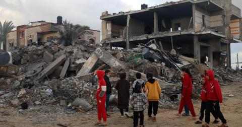 Barn ved ruiner av deres ødelagte hjem i Rafah, Gaza