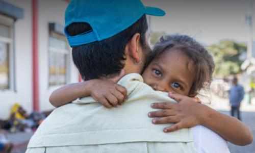 En jente klemmer en UNICEF-ansatt, Guatemala